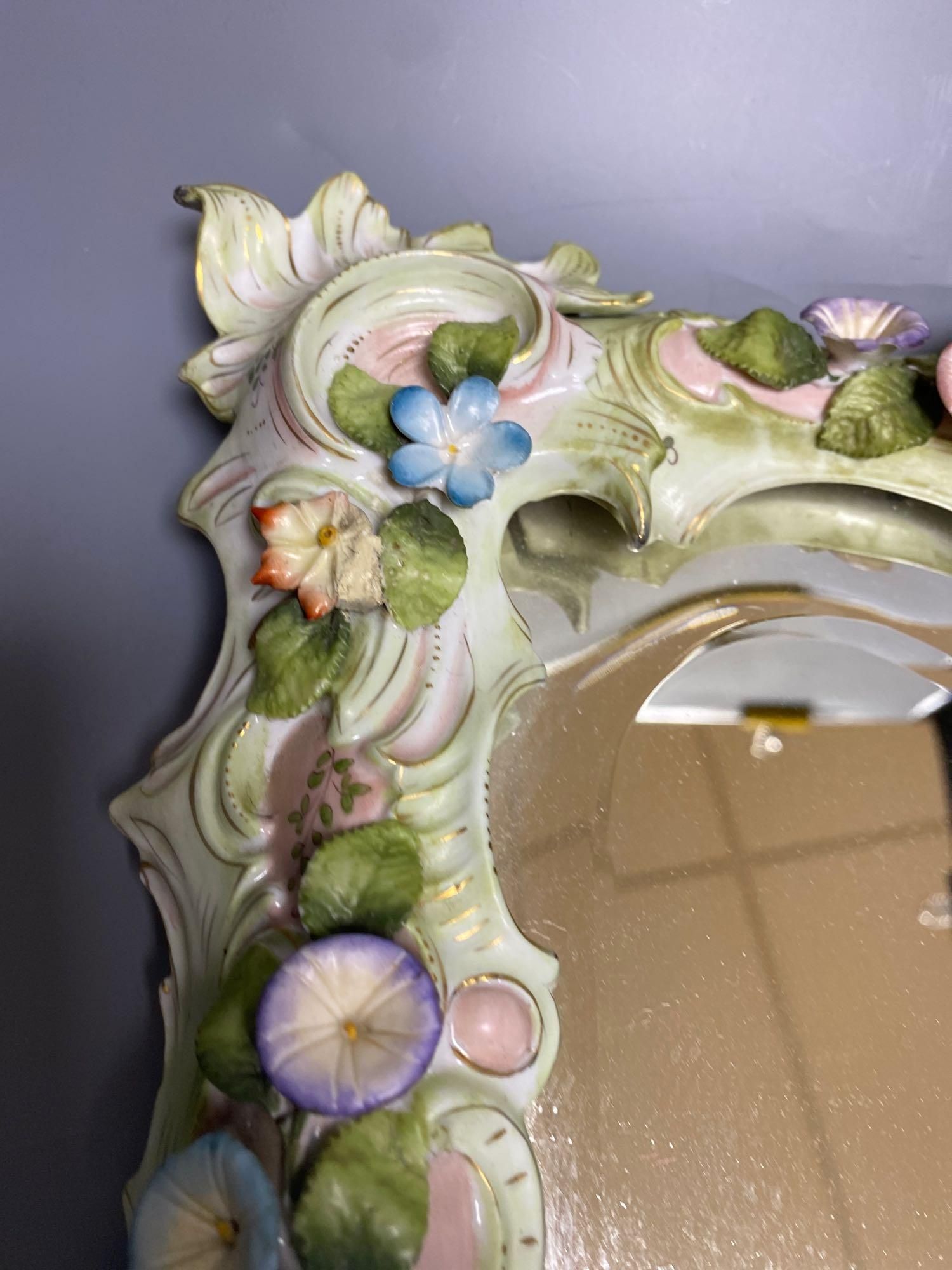 A porcelain floral encrusted wall mirror, German, Von Schierholz, 30 x 40cm
